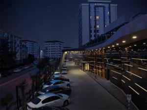 uma fila de carros estacionados ao lado de um edifício à noite em Shimall Deluxe em Gaziantep