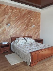 a bedroom with a bed and a wooden wall at Киевская 43 in Khorol
