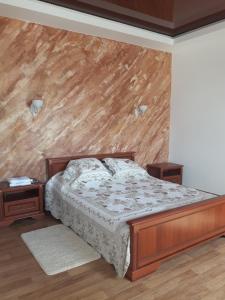 een slaapkamer met een bed en een houten muur bij Киевская 43 in Khorol