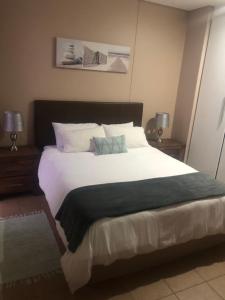 a bedroom with a large white bed with two lamps at Quayside 1001 Durban Point in Durban +28 photos