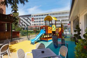 a playground with a slide and chairs and a building at Diamond Hotel - All Inclusive in Sunny Beach