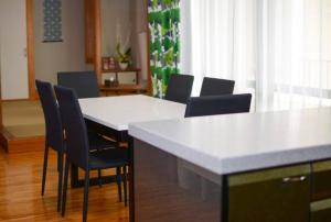 那覇市にあるGuest House Matsuyamaのキッチン(白いカウンター、椅子付)