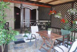 ein Holztisch und Stühle auf einer Terrasse in der Unterkunft Pension Antonakis Ouranoupolis Greece in Ouranoupoli