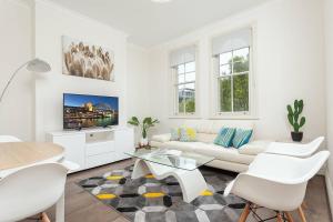 un soggiorno bianco con divano bianco e tavolo di STUNNING SYDNEY HOME 4 a Sydney
