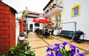 een patio met een parasol en een tafel en stoelen bij Dworek Familijny in Kołobrzeg