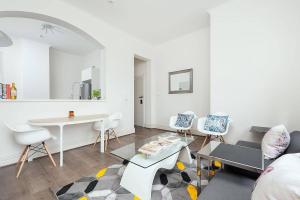 een woonkamer met een bank en een tafel en stoelen bij STUNNING SYDNEY HOME 7 in Sydney