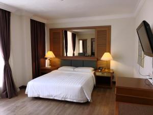 a hotel room with a bed and a mirror at The Executive Hotel Lahad Datu in Lahad Datu