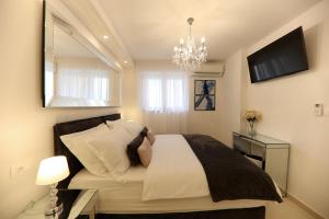 a bedroom with a bed with a mirror and a chandelier at KIKO Luxury Accommodation in Zadar