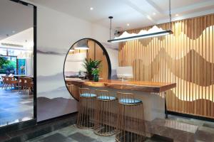 a bar with a mirror and three stools at Li River Resort Villa Hotel in Guilin