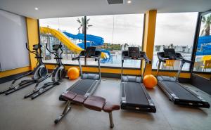 a gym with several tread machines and a pool at Campus Hill Hotel in Alanya