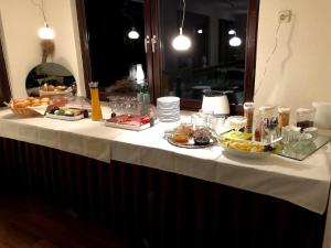 a table with a white table cloth with food on it at Hotel garni Zum Adenauer Forst in Wimbach