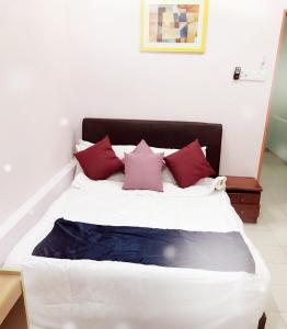 a large white bed with red pillows in a room at Bukit Bentong Homestay in Bentong