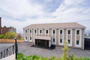 a large white building with a roof at Hotel Chalet in Vladivostok