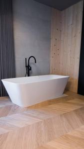 a white bath tub sitting on a wooden floor in a bathroom at Cirna Gentle Luxury Lodges in Naturno