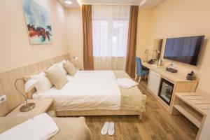 a hotel room with two beds and a flat screen tv at Hotel Mar Garni in Belgrade