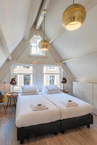 a large white bed in a room with windows at Residences Jordan 9 Streets in Amsterdam