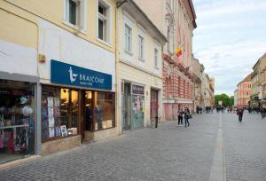 a street in a city with people walking on the street at Republicii Residence in Braşov
