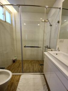 uma casa de banho com um chuveiro, um WC e um lavatório. em Chien Ching B&B em Jiufen