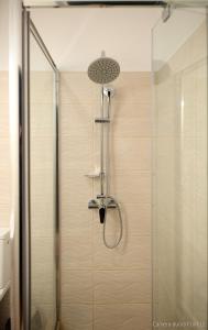 a shower with a shower head and a glass door at Republicii Residence in Braşov +88 photos