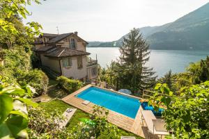 uma casa com uma piscina ao lado de uma massa de água em B&B Villa Costanza em Blevio