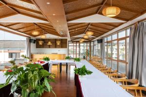 a dining room with tables and chairs and windows at Floral Hotel · Yingxi Riverside Deqing in Deqing