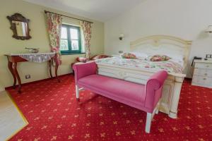 Un dormitorio con una cama y una silla rosa. en Boutique Hotel Pri Mlyne Lozorno, en Lozorno 83 fotos más