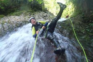 a man is on a rope in a waterfall at Apartamentos El Castañeu in Corao