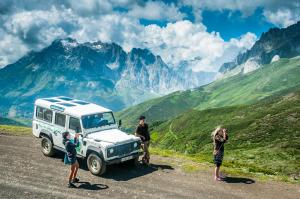 a group of people standing next to a jeep on a mountain at Apartamentos El Castañeu in Corao