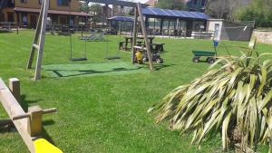 a park with a playground with swings at Apartamentos El Castañeu in Corao