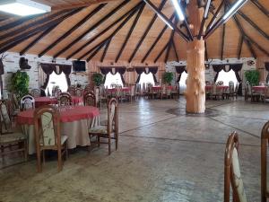 ein Esszimmer mit Tischen und Stühlen in einer Scheune in der Unterkunft HANUL VANATORULUI in Gura Humorului