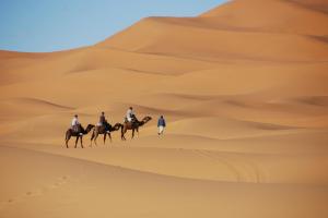 Un groupe de personnes à cheval dans le désert dans l'établissement Moonlight Desert Camp, à Merzouga