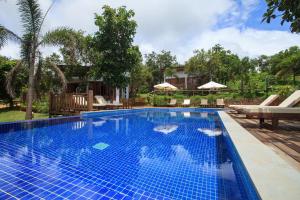 a large swimming pool with blue tiles in a yard at Mayura Hill Resort in Sen Monorom