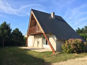 ein kleines Haus mit einem Gamer-Dach und einer Veranda in der Unterkunft Vacances à la Mer la Turballe Ajonc in La Turballe