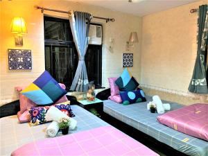 I Top International Guesthouse في هونغ كونغ: غرفة معيشة مع سريرين مع وسائد ملونة