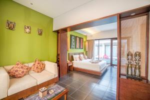 a living room with green walls and a couch at Gaing Mas Jimbaran Villas by Gaing Mas Group in Jimbaran