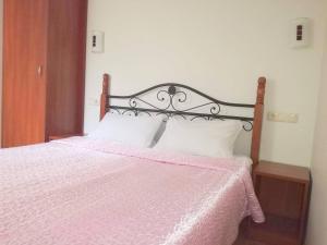 a bedroom with a pink bed with white pillows at Agava in Palanga