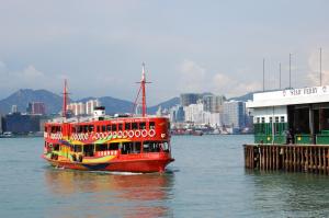 a red boat in the water next to a pier at I Top International Guesthouse in Hong Kong
