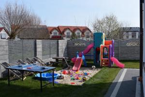 a backyard with a playground with a table and play equipment at Sunrise Apartaments in Rowy