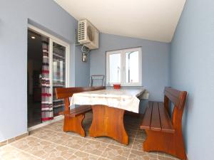 a dining room with a table and two benches at Apartments Dragica 1251 in Fažana