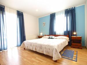 a bedroom with a bed with blue walls and windows at Apartments Dragica 1251 in Fažana