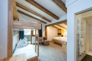 a room with a bunk bed and a bedroom at Pension Restaurant Dorfalm in Leogang