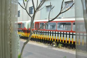 un treno rosso e giallo parcheggiato accanto a un edificio di Village Villa B&B a Zhuqi