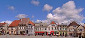 a group of buildings with people walking in a square at Zefir in Darłowo