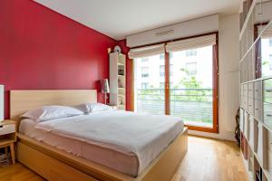 a red bedroom with a bed and a window at Veeve - Modern Brights in Paris
