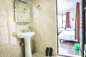 un baño con lavabo y espejo en Hotel K2 Pokhara, en Pokhara