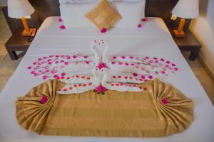 Una cama con dos toallas y flores. en River Loft Nature Resort, en Pathegama