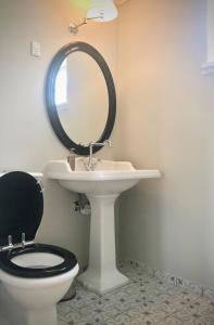 a bathroom with a toilet and a sink with a mirror at Havgaarden Badehotel in Vejby