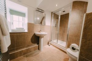 a bathroom with a tub, toilet, sink and shower at Ramada Resort Cwrt Bleddyn Hotel & Spa in Usk