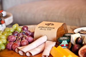 d'Olyfboom Guest House B & B في بارل: طاولة مع صندوق من الخبز والشرب والفواكه والخضروات