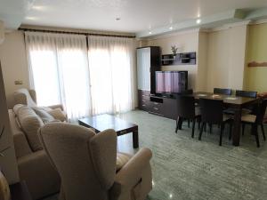a living room with a table and a dining room at Apartamentos Deluxe San Julian in Torrevieja